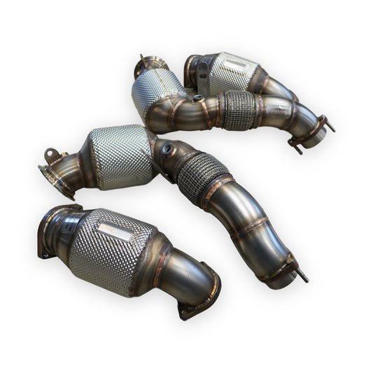 Vier Rohre der MxM Downpipes S63 mit Hitzeschutzmantel