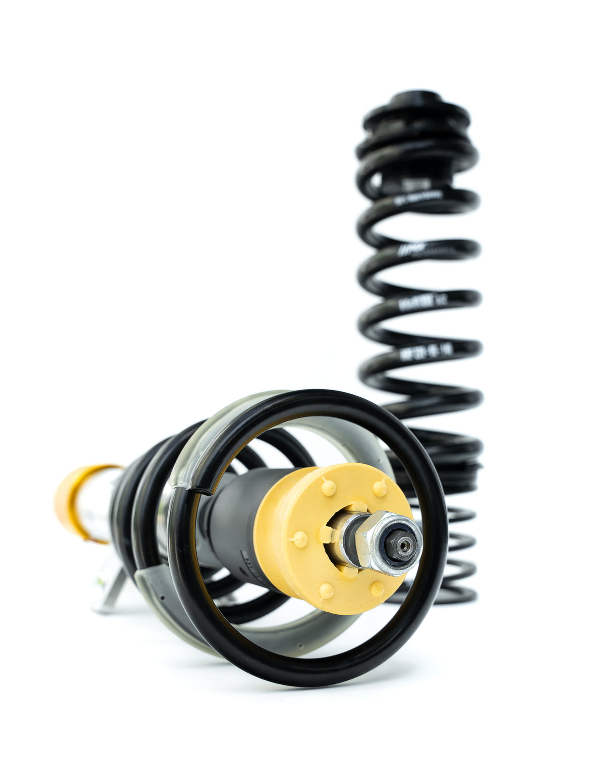 Federbein des MxM × H&R DCS+ Gewindefahrwerks von unten, dahinter eine Hinterachsfeder